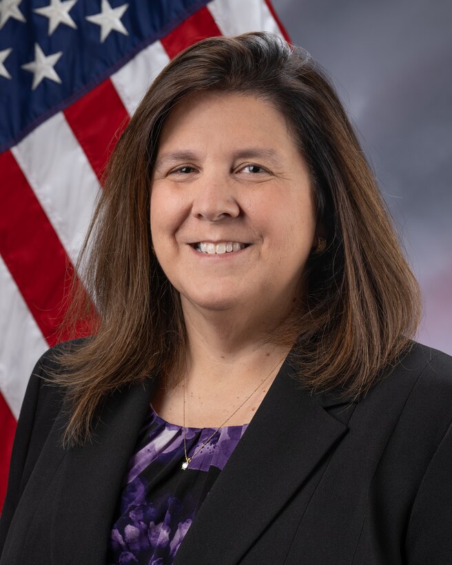 woman in business attire with american flag in background