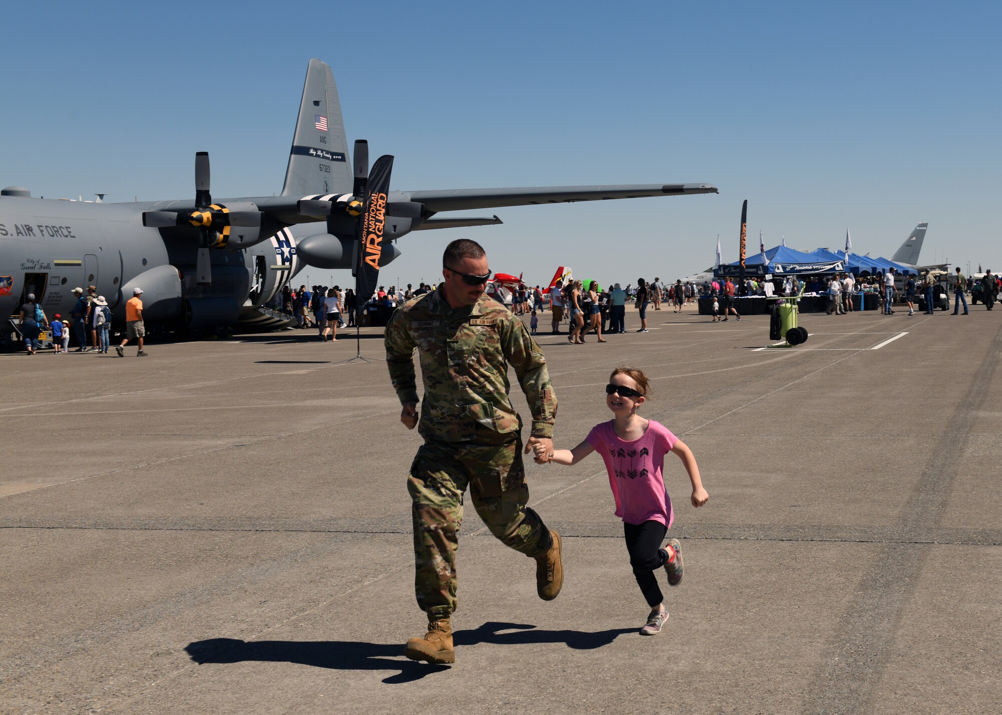 Spectators make their way hastily to a new attraction during
Montana's Military Open House "Flight over the Falls" at Montana Air National Guard Base, Great Falls, Montana, July 23, 2022.