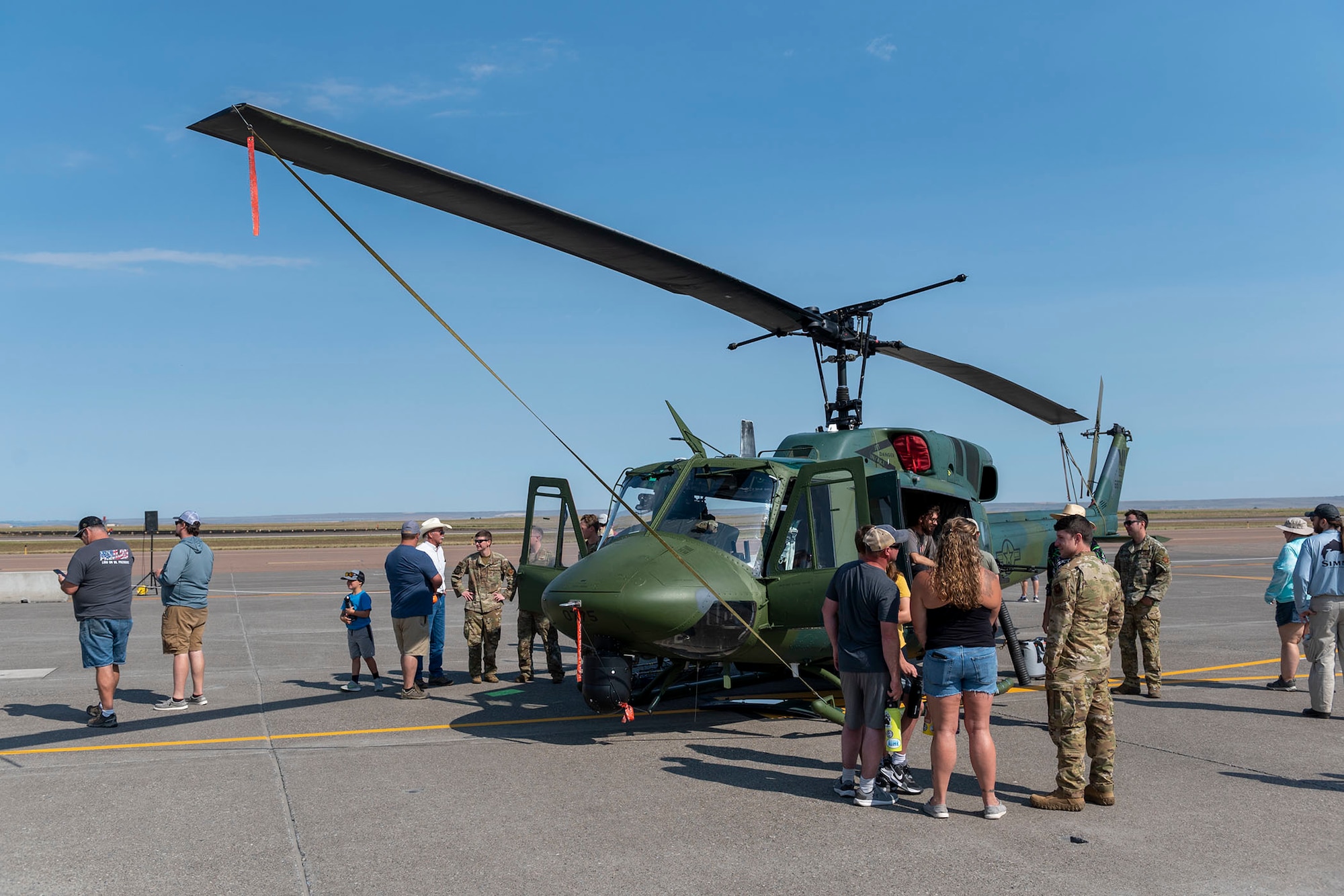Members of the local community view a Bell UH-1N Twin "Huey" from the 40th Helicopter Squadron's static display during the Montana's Military Open House "Flight over the Falls" at Montana Air National Guard Base, Great Falls, Montana, July 24, 2022.