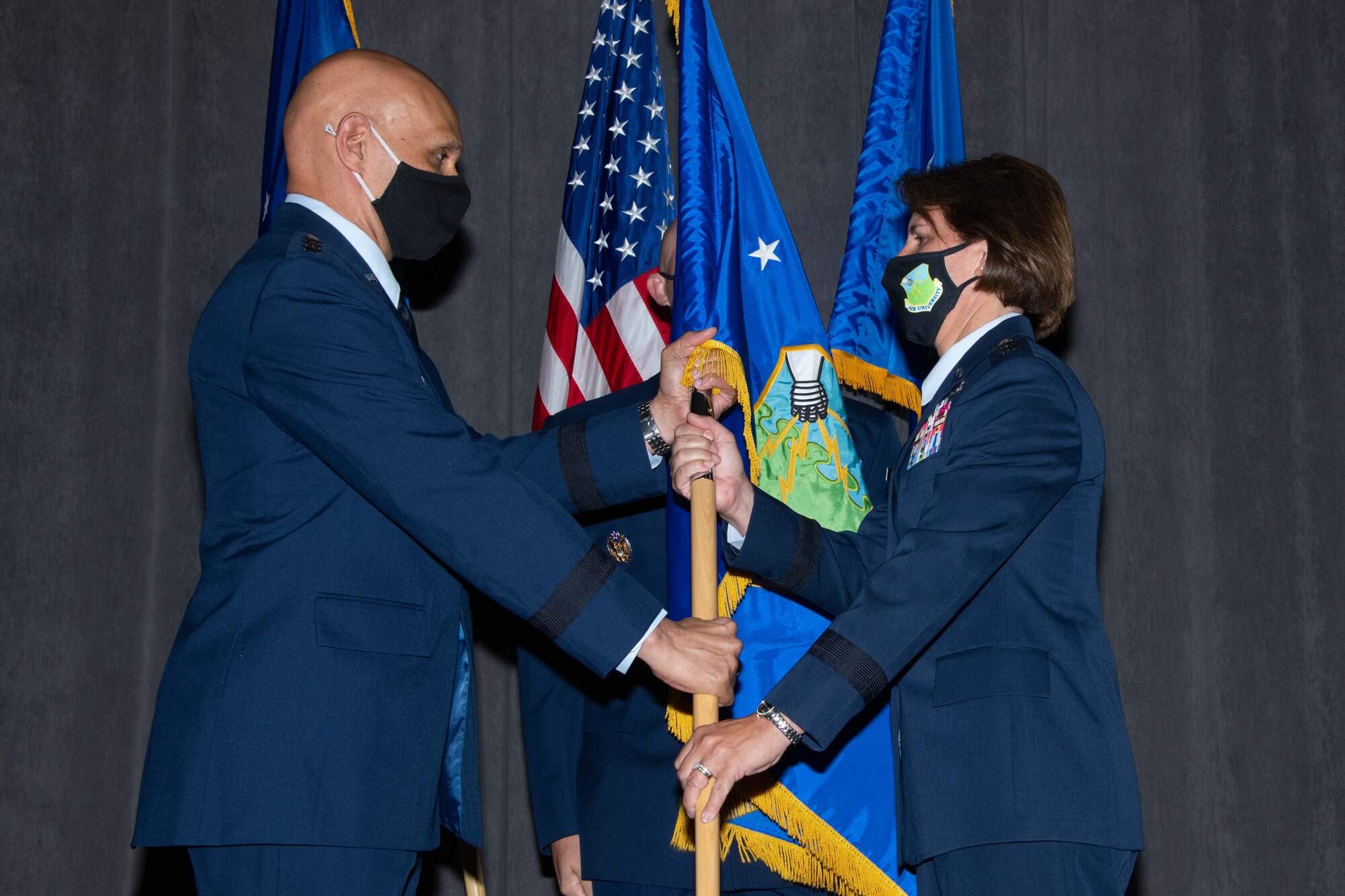 Lt. Gen. Brian Robinson, commander of Air Education and Training Command, hands the Air University guidon to Lt. Gen. Andrea Tullos during the Air University Assumption of Command Ceremony at Maxwell Air Force Base, Alabama, July 25, 2022. Tullos served as the commander of Maxwell’s 42nd Air Base Wing from 2014 to 2016, and before assuming command of Air University, she was the deputy commander of AETC. (U.S. Air Force photo by Melanie Rodgers Cox)