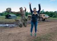 Sgt. Amanda Kiley and Bonnie Montague jump for joy during 3rd Battalion, 197th Field Artillery Brigade's annual training at Fort Drum, New York, July 21, 2022. Kiley and Montague work together in the civilian sector at Community Partners, a community mental health center.