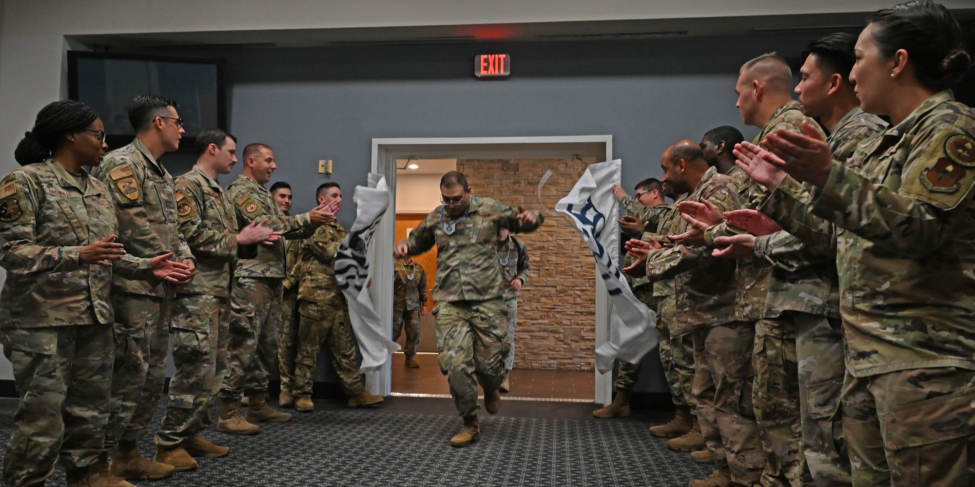 U.S. Air Force Staff Sgt. Garret Benjamin, 316th Training Squadron instructor, celebrates his achievement during the technical sergeant release party at the Powell Event Center, Goodfellow Air Force Base, Texas, July 22, 2022. Coworkers and family members congratulated selectees before they received their certificates. (U.S. Air Force photo by Senior Airman Michael Bowman)