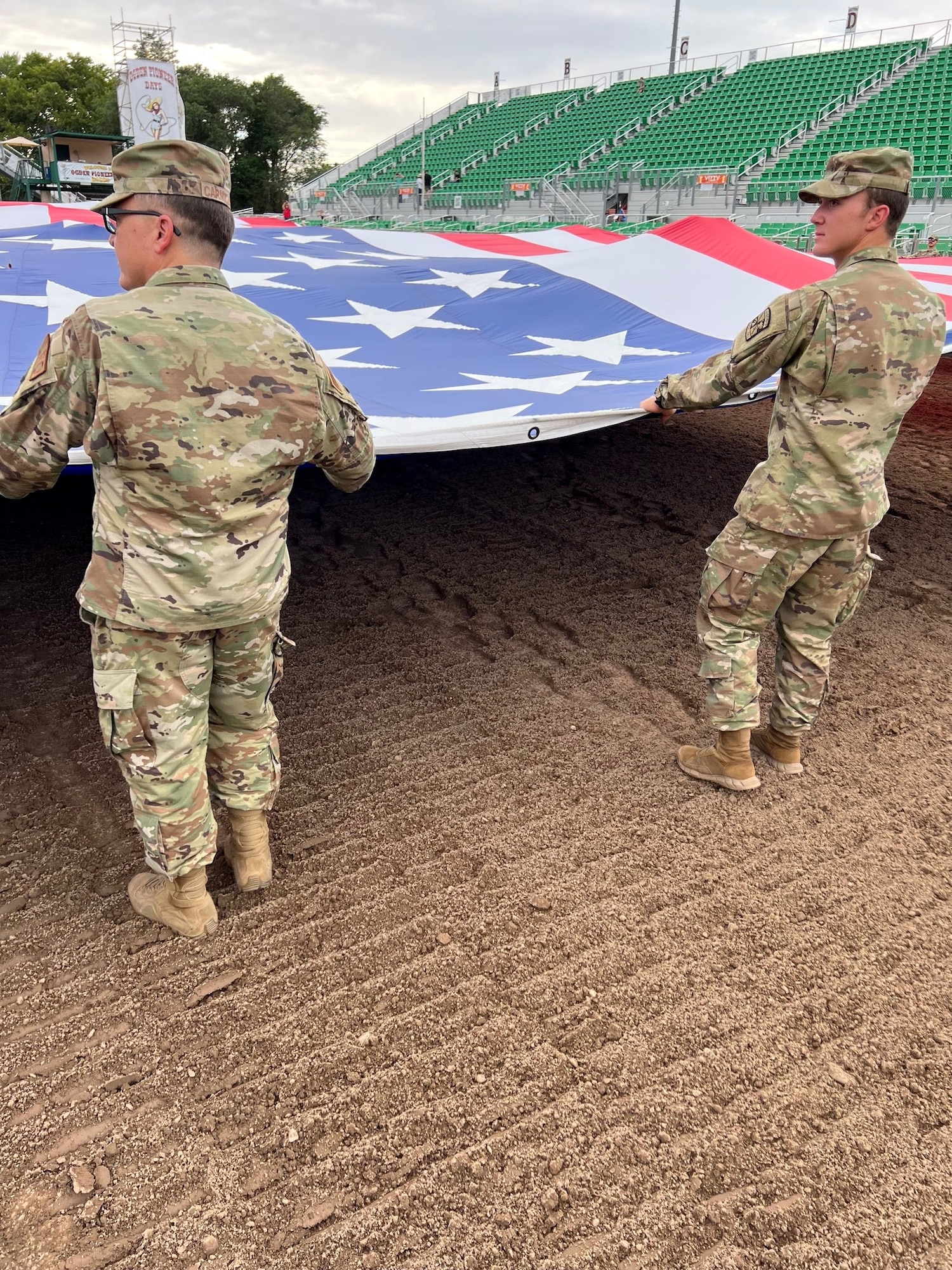 Left, Col. Christopher Carmichael, 748th Supple Chain Management Group commander, and his son, Air Force Cadet Skip Carmichael unfurl The Major, a giant American flag, in a practice run before Patriot Night at the Ogden Pioneer Days Rodeo opening ceremony July 22, 2022, in Ogden,
