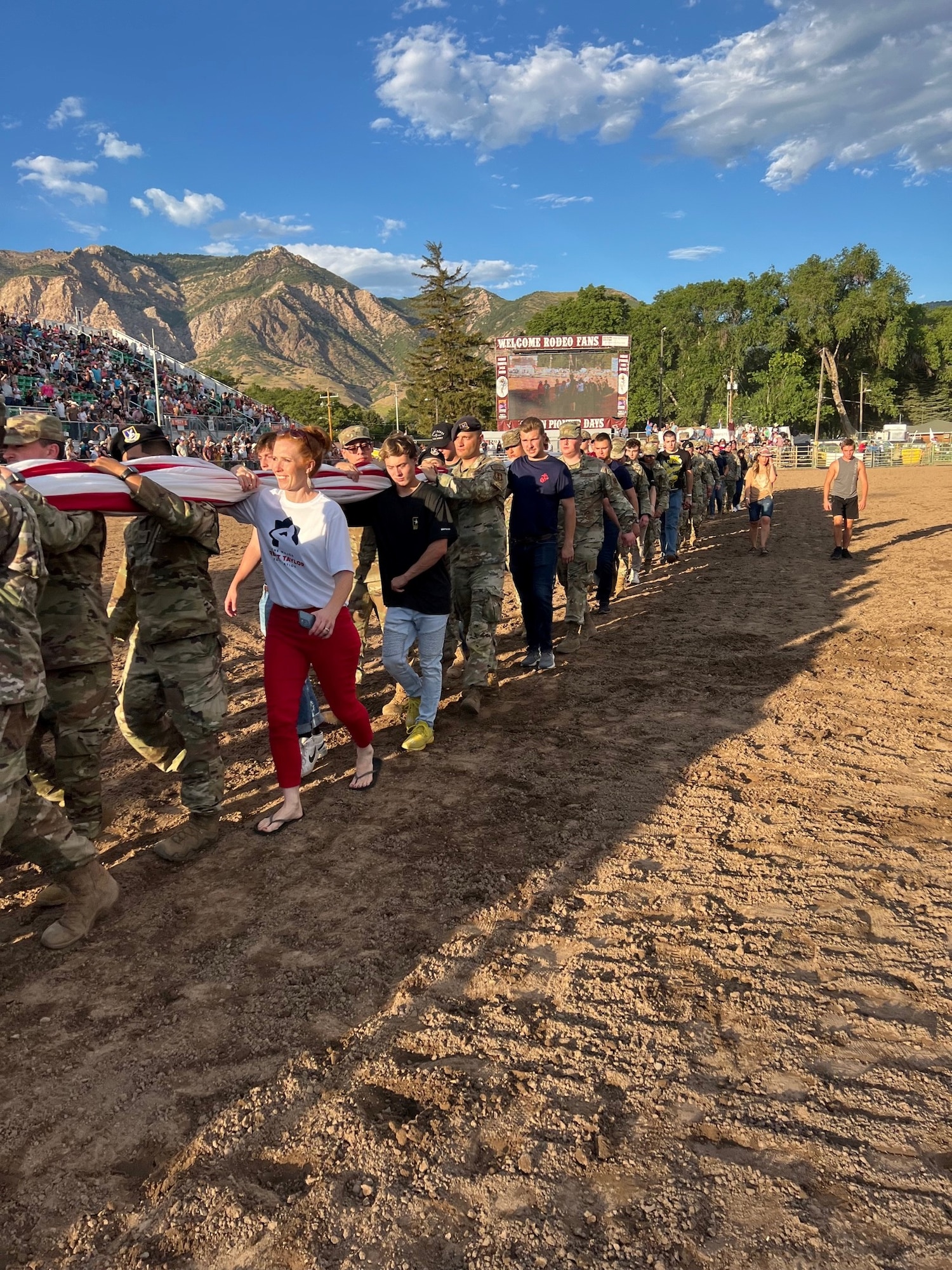 Jennie Taylor, (red pants) patriots from Hill AFB and other Utah service members celebrated Patriot Night at the Ogden Pioneer Days Rodeo opening ceremony July 22, 2022, by transporting “The Major,” a giant American flag in Ogden, Utah.