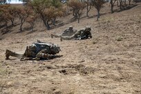 Soldiers from Avalanche Company, 1st Battalion, 297th Infantry Regiment move tactically in a high crawl with their weapons during a live fire exercise at Camp Roberts, California July 23, 2022. Over the course of three weeks, the infantry battalion conducted several situational training, live fire, and field exercises while adapting to new climates and terrain. (Alaska National Guard photo by Staff Sgt. Katie Mazos-Vega)