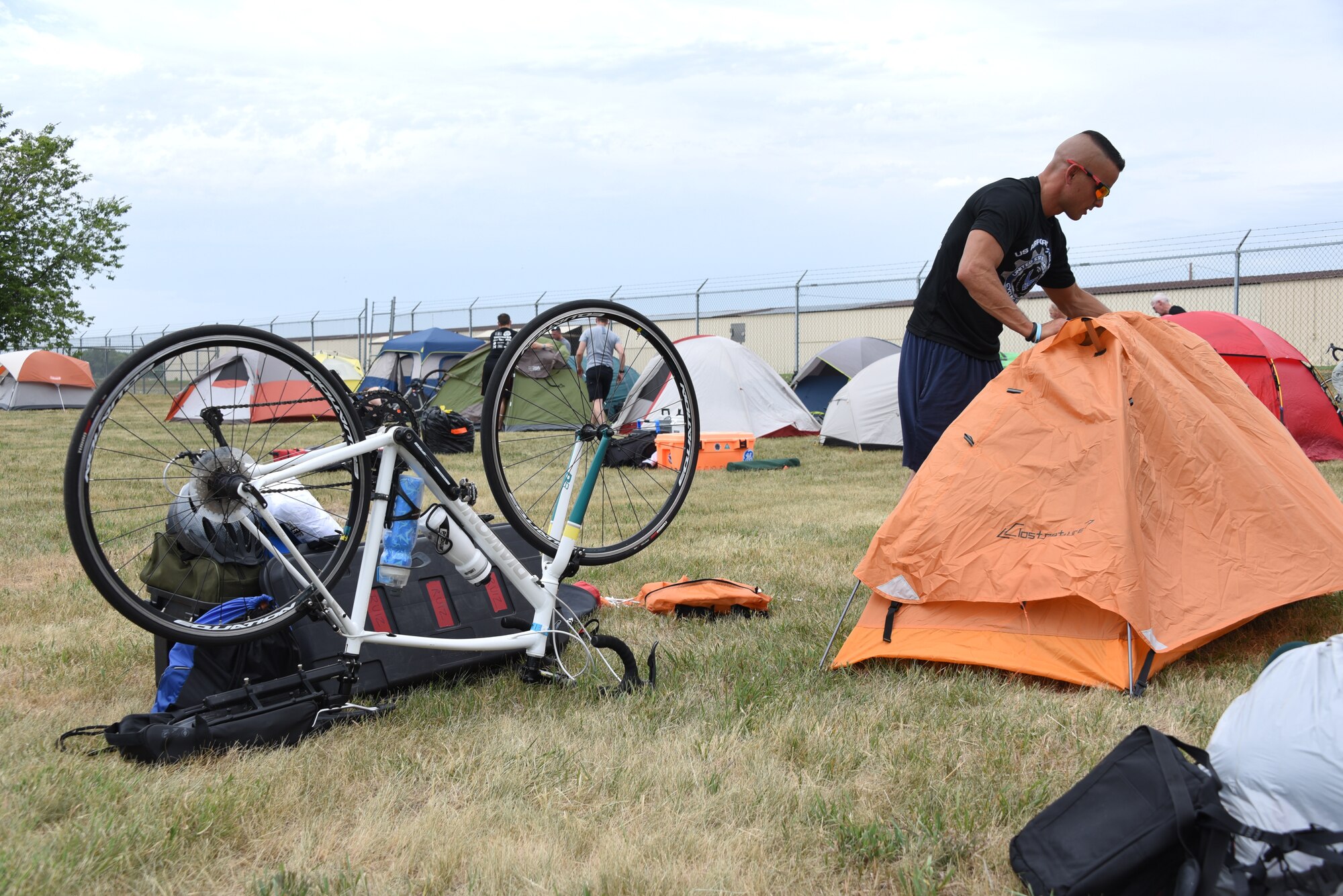 An AFCT member attaches a rain cover to a tent