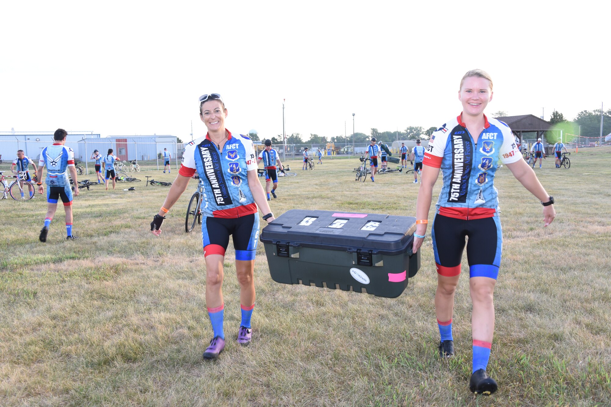 Two Airmen carry a hard case