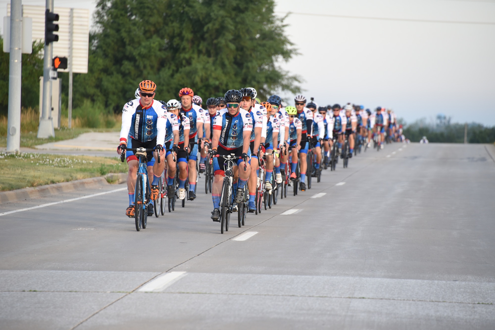 AFCT members ride two-by-two down a road