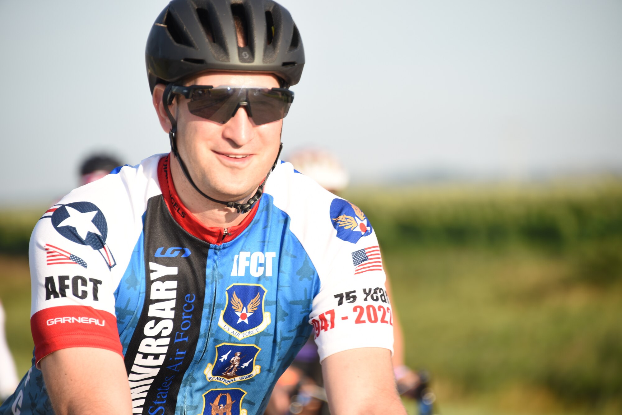 AFCT member rides in front of a field