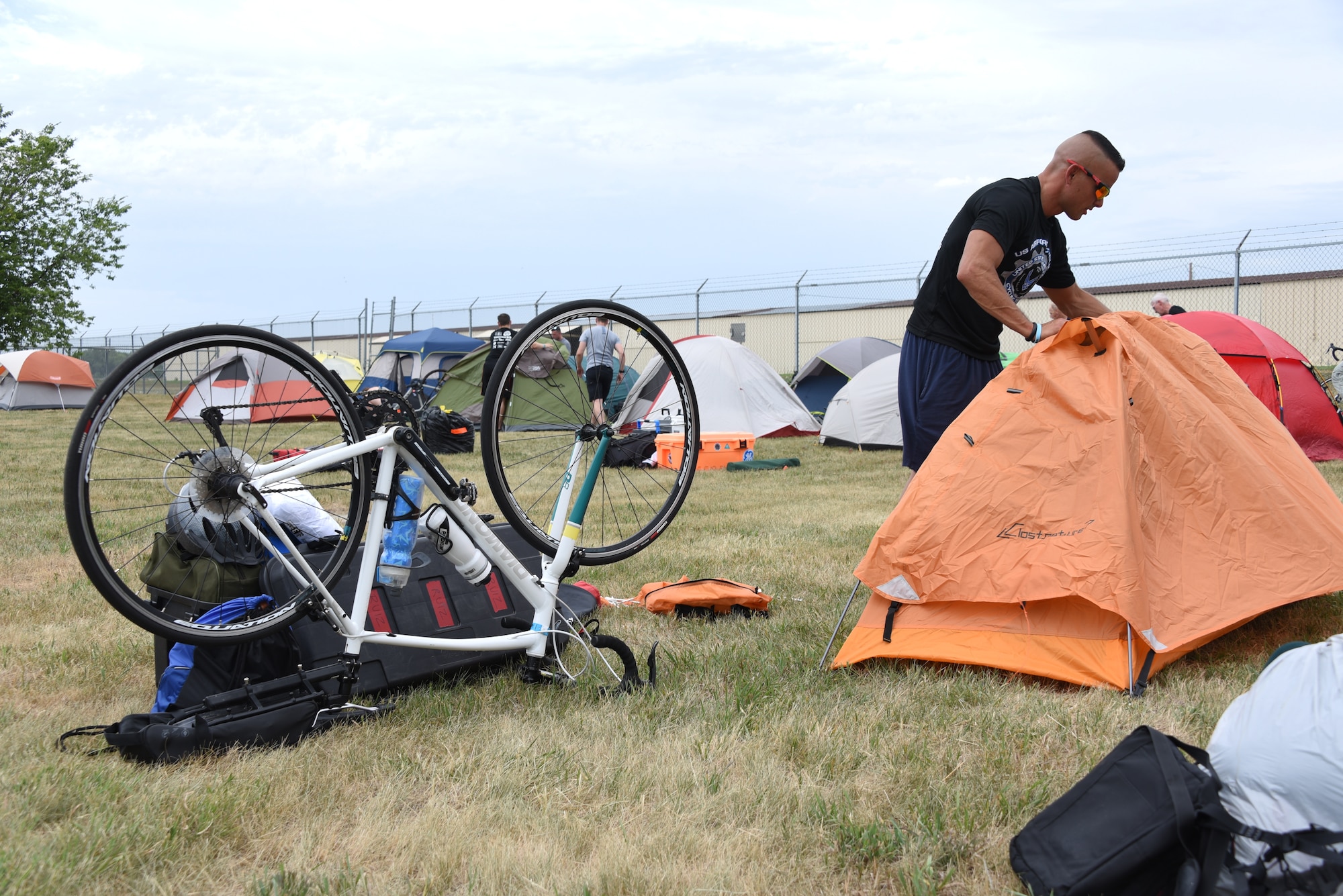 An AFCT member attaches a rain cover to a tent