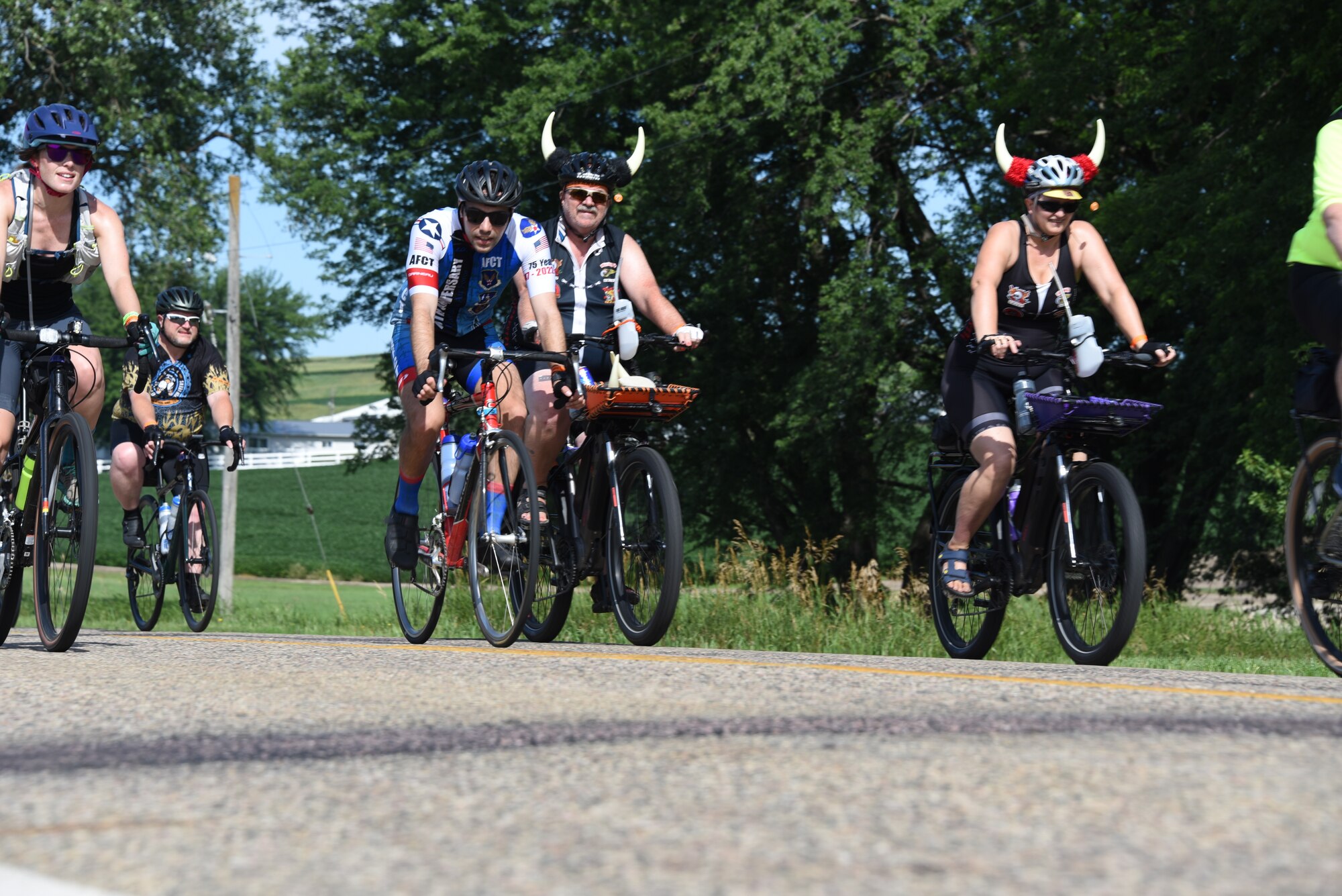 AFCT member rides next to cyclists with cycling helmets with horns