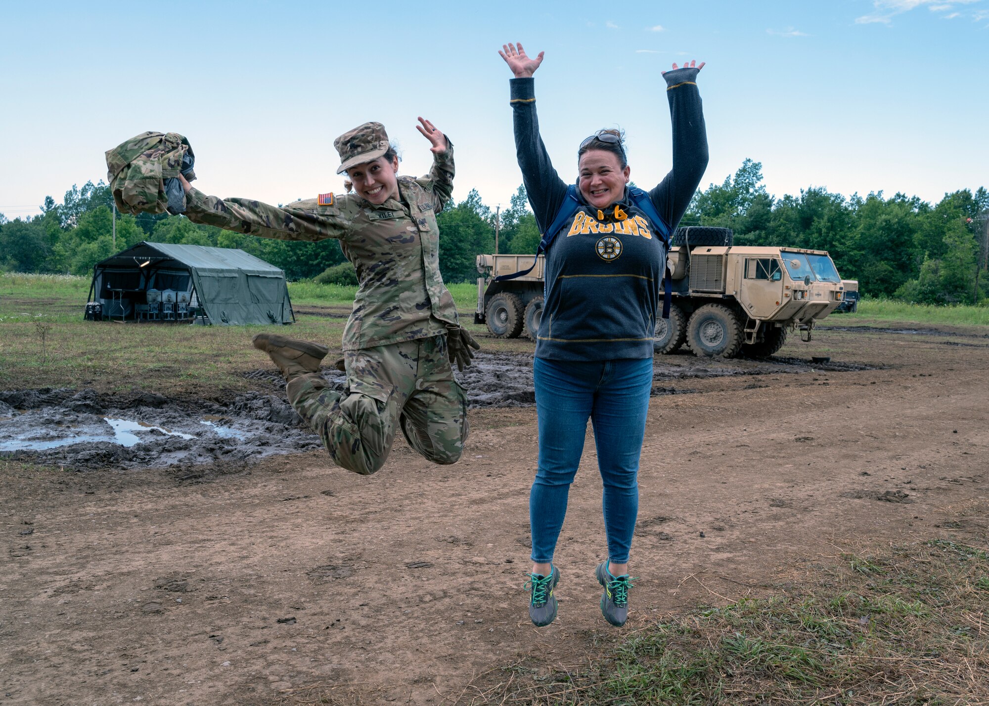Sgt. Amanda Kiley and Bonnie Montague jump for joy during 3rd Battalion, 197th Field Artillery Brigade's annual training at Fort Drum, New York, July 21, 2022. Kiley and Montague work together in the civilian sector at Community Partners, a community mental health center.
