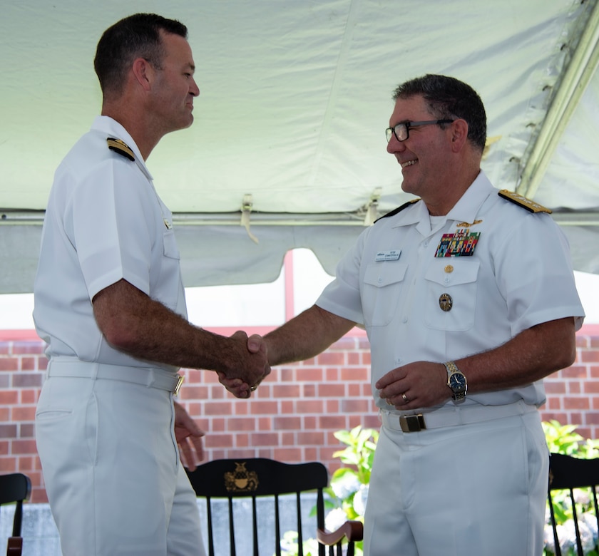 NEWPORT, RI. (July 22, 2022) Capt. Michael York, commanding officer, Navy Supply Corps School (NSCS), shakes hands with Rear Adm. Peter Stamatopoulos, commander, Naval Supply Systems Command, and 49th Chief of Supply Corps, right during the NSCS change of command ceremony at Naval Station Newport, July 22. NSCS prepares newly commissioned Supply Corps officers from the U.S. Naval Academy, Officer Candidate School and Naval Reserve Officers Training Corps, as well as limited duty officers or officers who have been re-designated into the community, to serve in the fleet in entry-level positions. (U.S. Navy photo by Mass Communication Specialist 2nd Class Derien C. Luce)