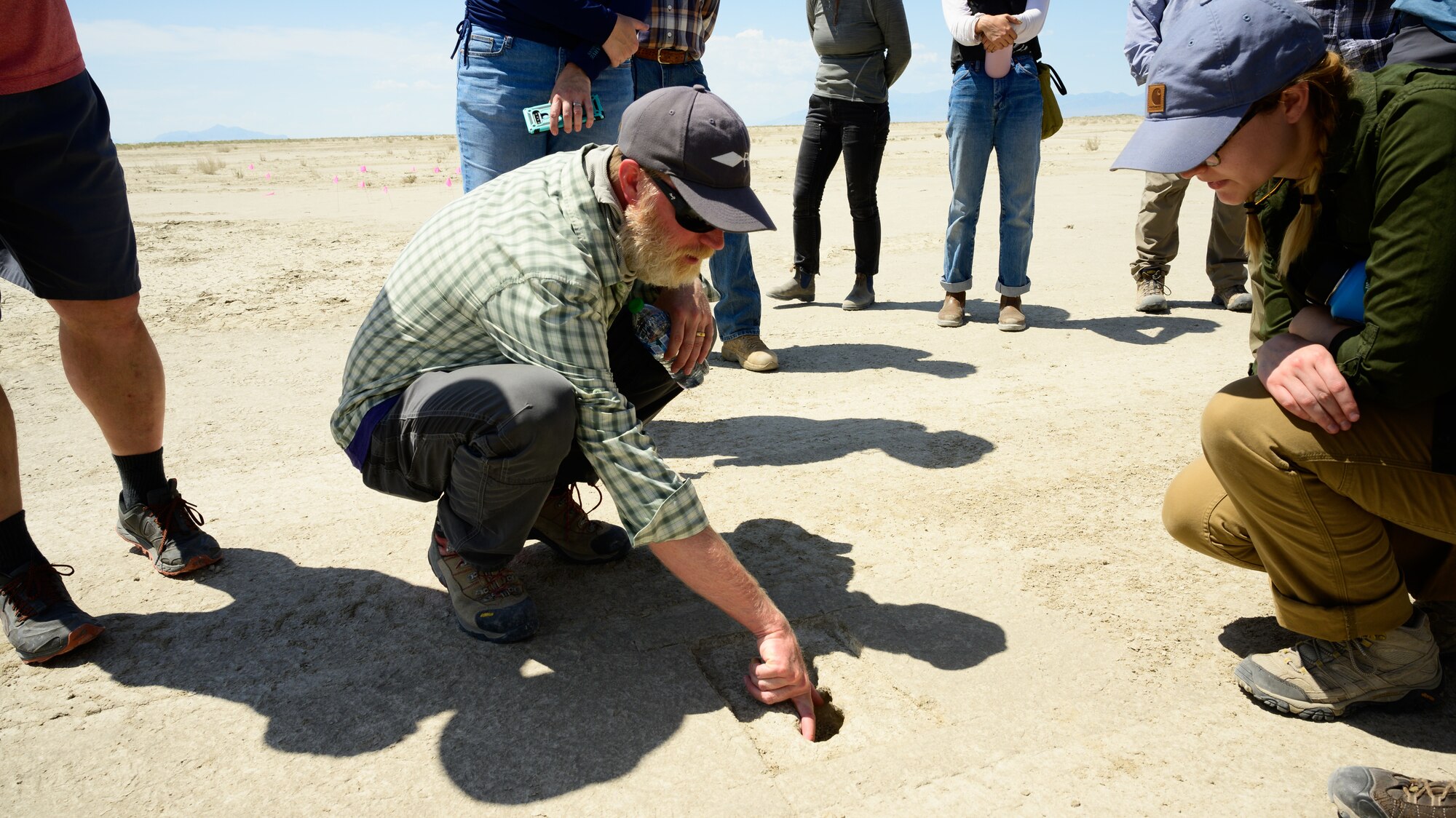 A footprint appears on an archaeological site as Daron Duke and others look on in the background.