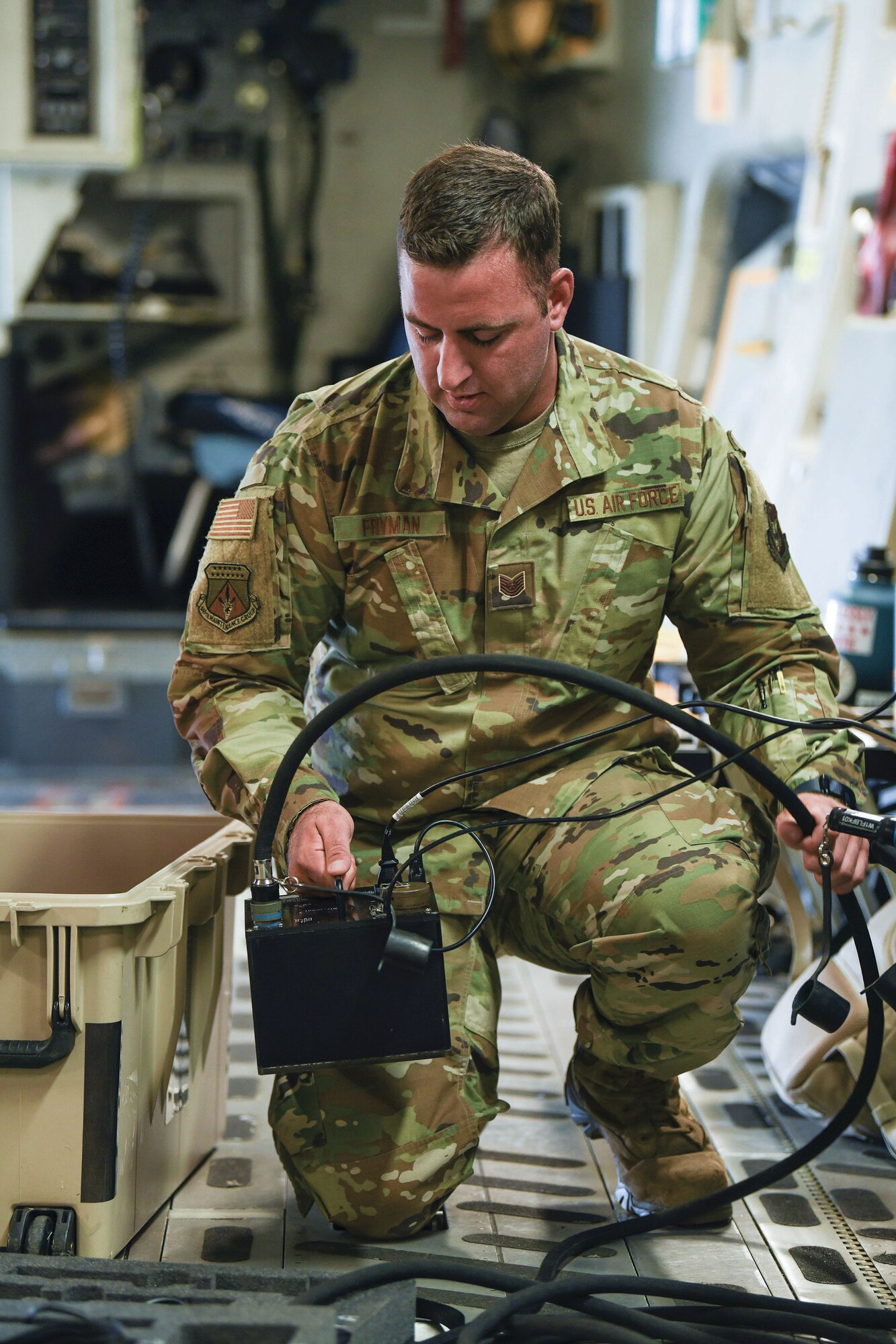 Tech. Sgt. Bradley Fryman, 445th Aircraft Maintenance Squadron communication navigation specialist, sets up communication systems equipment aboard a C-17 Globemaster III aircraft, July 9, 2022