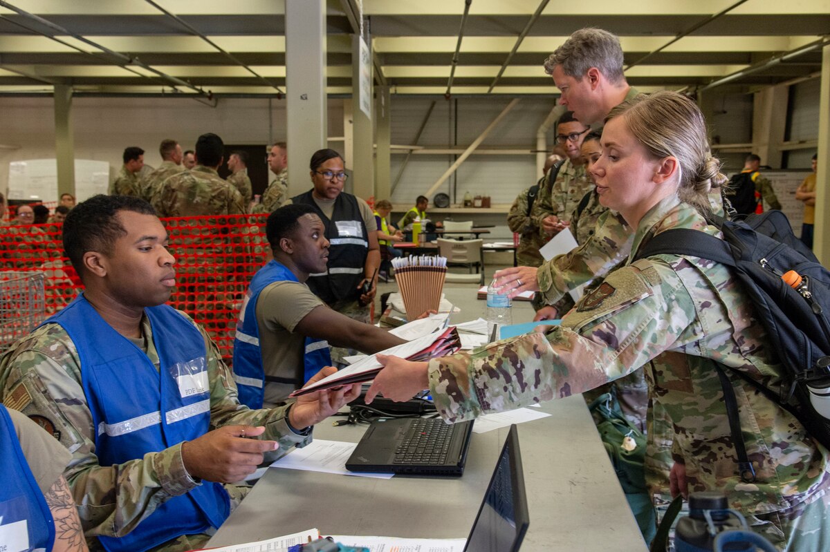 Team Dover members process through the personnel deployment function line during Liberty Eagle Readiness Exercise 2022 at Dover Air Force Base, Delaware, July 11, 2022. The 436th and 512th Airlift Wings tested their ability to generate, employ and sustain airpower across the world in a simulated contested and degraded operational environment. (U.S. Air Force photo by Roland Balik)