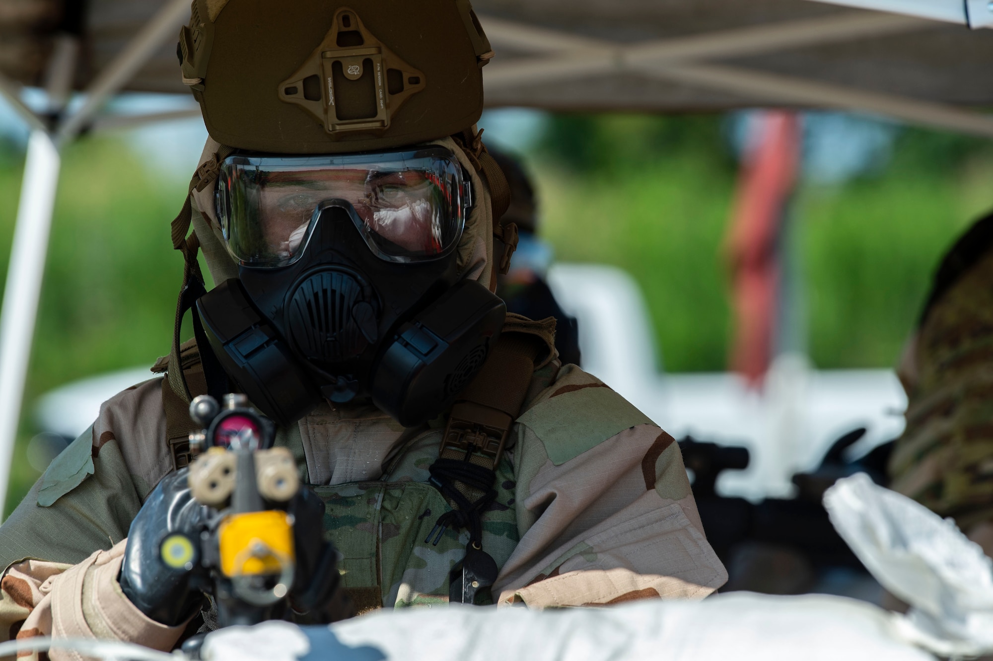 A Team Dover member wearing training protective gear stands guard against possible intruders at a simulated forward operating base during Liberty Eagle Readiness Exercise 2022 at Dover Air Force Base, Delaware, July 13, 2022. The 436th and 512th Airlift Wings tested their ability to generate, employ and sustain airpower across the world in a contested and degraded operational environment. (U.S. Air Force photo by Roland Balik)