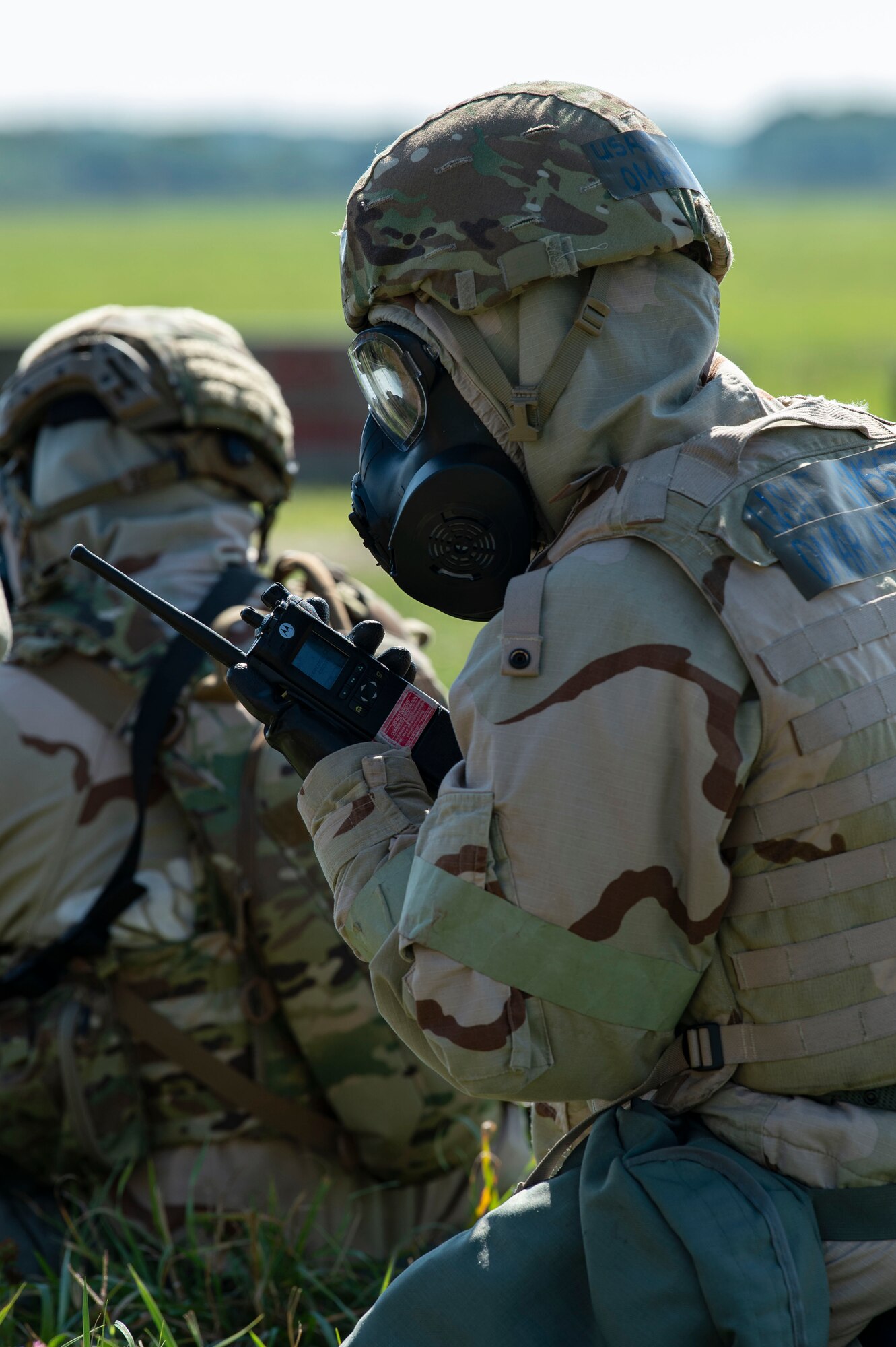 A Team Dover member listens to his radio while wearing training protective gear as he sits in a simulated shelter during Liberty Eagle Readiness Exercise 2022 at Dover Air Force Base, Delaware, July 13, 2022. The 436th and 512th Airlift Wings tested their ability to generate, employ and sustain airpower across the world in a contested and degraded operational environment. (U.S. Air Force photo by Roland Balik)