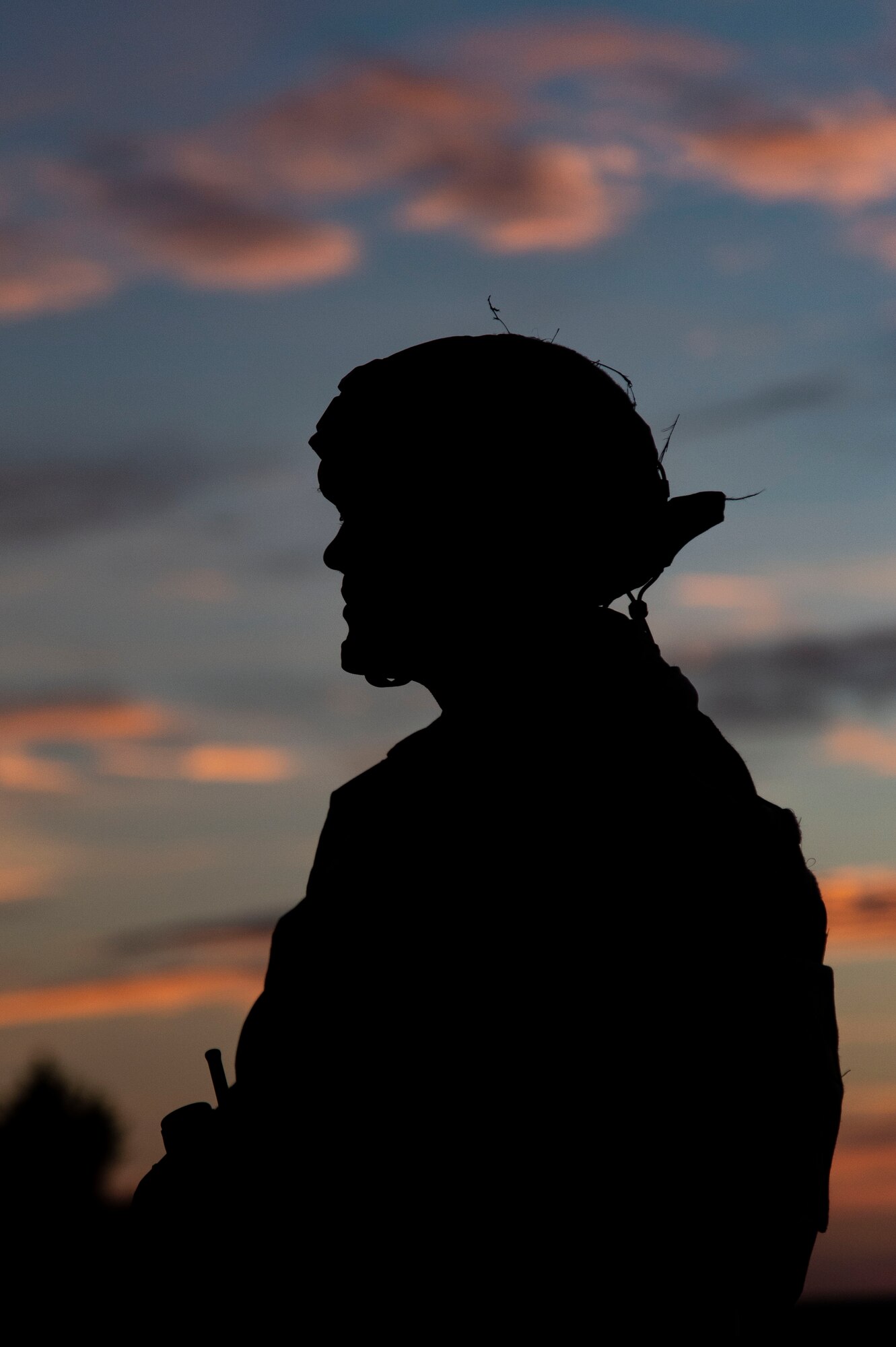 A Team Dover member stands guard at sunset during Liberty Eagle Readiness Exercise 2022 at Dover Air Force Base, Delaware, July 13, 2022. The 436th and 512th Airlift Wings tested their ability to generate, employ and sustain airpower across the world in a contested and degraded operational environment. (U.S. Air Force photo by Roland Balik)