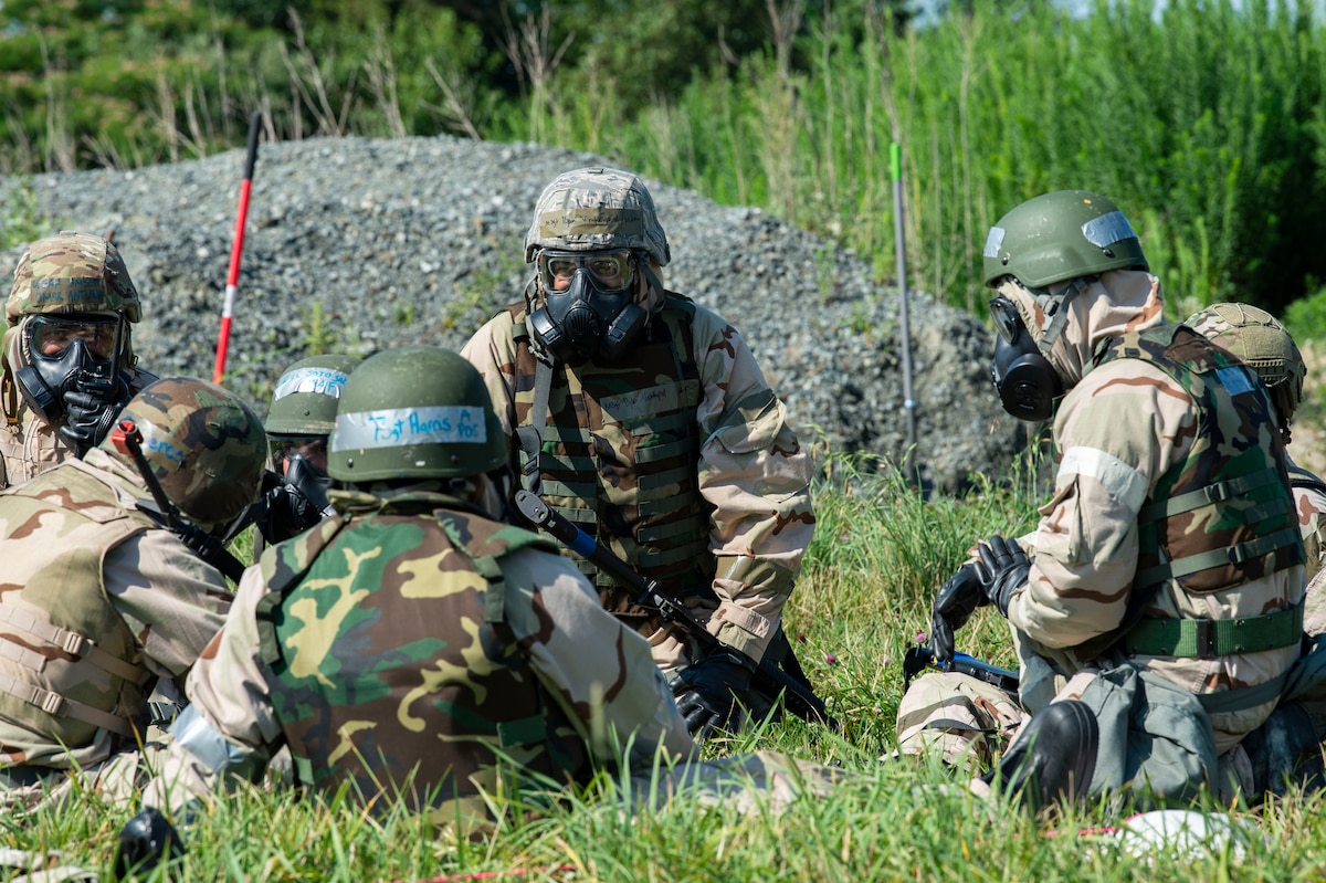 Team Dover members wearing training protective gear at a simulated forward operating base, sit in a simulated shelter during Liberty Eagle Readiness Exercise 2022 at Dover Air Force Base, Delaware, July 13, 2022. The 436th and 512th Airlift Wings tested their ability to generate, employ and sustain airpower across the world in a contested and degraded operational environment. (U.S. Air Force photo by Roland Balik)