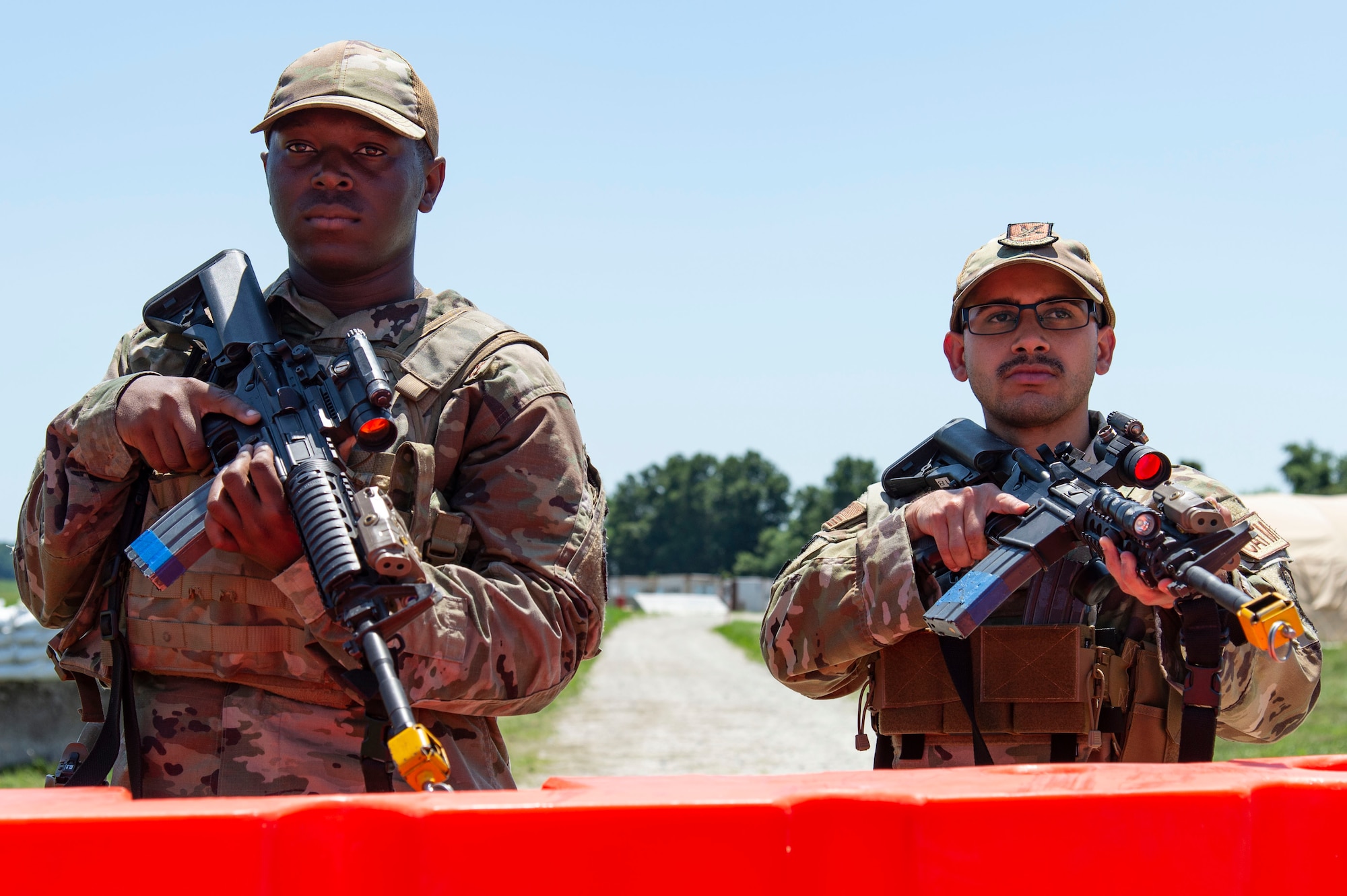Senior Airmen Qwesi Benson, left, 436th Security Forces Squadron response force member, and Jose Martinez, right, 436th SFS combat arms training and maintenance instructor, stand guard at a simulated forward operating base during Liberty Eagle Readiness Exercise 2022 at Dover Air Force Base, Delaware, July 12, 2022. The 436th and 512th Airlift Wings tested their ability to generate, employ and sustain airpower across the world in a simulated contested and degraded operational environment. (U.S. Air Force photo by Roland Balik)
