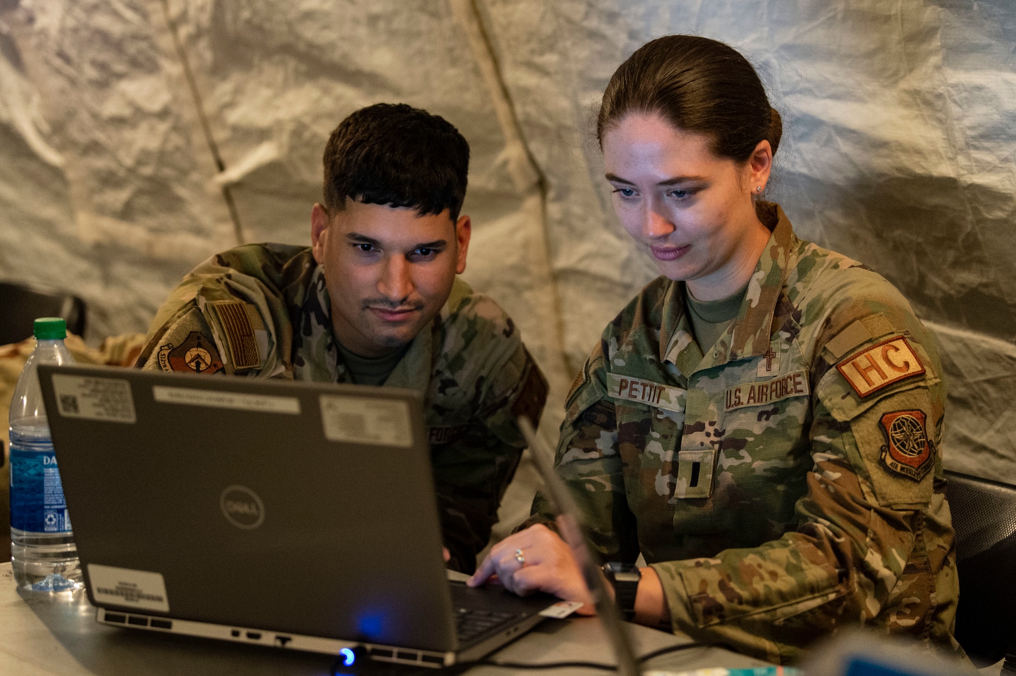 Tech. Sgt. Eric Feliciano, left, 512th Airlift Wing religious affairs airman, and 1st Lt. Rebecca Pettit, right, 436th Airlift Wing chaplain, check network connectivity during Liberty Eagle Readiness Exercise 2022 at Dover Air Force Base, Delaware, July 13, 2022 at Dover Air Force Base, Delaware, July 13, 2022. The 436th and 512th Airlift Wings tested their ability to generate, employ and sustain airpower across the world in a contested and degraded operational environment. (U.S. Air Force photo by Roland Balik)