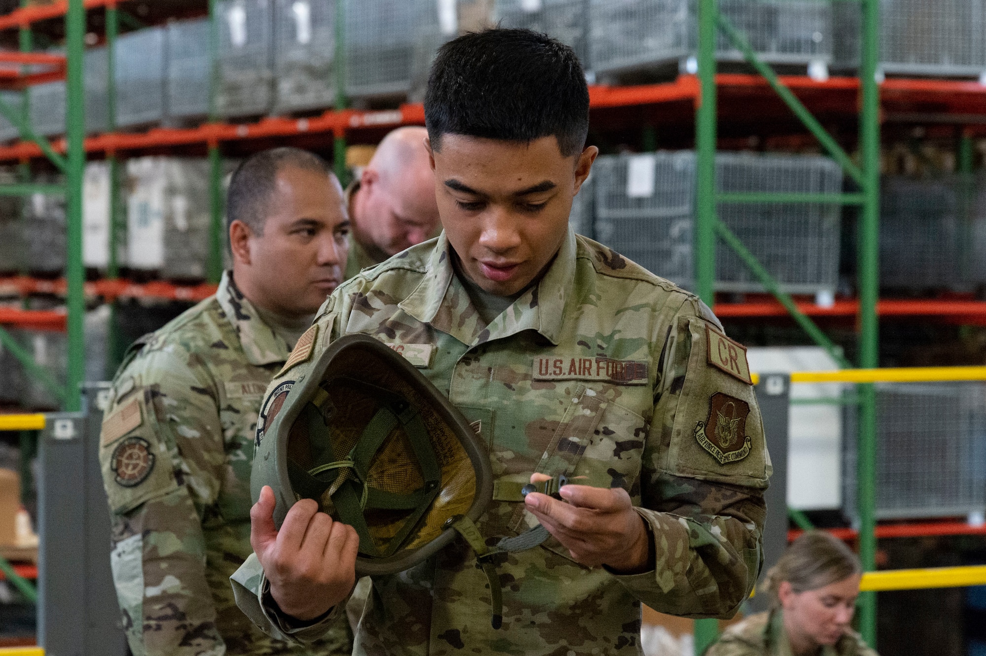 Senior Airman Darian Davis Jr., 512th Contingency Response Squadron command and control journeyman, checks his helmet chin strap as he processes through the personnel deployment function line during Liberty Eagle Readiness Exercise 2022 at Dover Air Force Base, Delaware, July 11, 2022. The 436th and 512th Airlift Wings tested their ability to generate, employ and sustain airpower across the world in a simulated contested and degraded operational environment. (U.S. Air Force photo by Roland Balik)