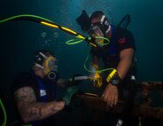 A U.S. Navy diver and a Mexican navy diver conduct hot tap training during RIMPAC 2022.