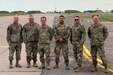 Pennsylvania Air National Guardsmen, from left, Lt.Col. Frank Shoaf, Chief Master Sgt. Jason Everetts, Capt. Matthew Reed, Master Sgt. Frankie Perez, Chief Master Sgt. Andrew Mowry, and Capt. Benjamin Kaufman with the 171st Air Refueling Wing’s geographically separated unit the 258th Air Traffic Control Squadron located in Johnstown, Pennsylvania, pose for a photo at Siauliai Air Base, Lithuania, while attending joint exercise, Defender Europe-22, June 2022. The purpose of the engagement was focused on capability sharing and discussion of future State Partnership Program events between the 258th and the Lithuanian Air Force.