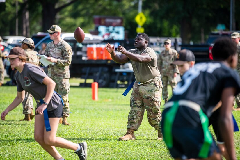 Soldiers and high school students play flag football during summer camp.