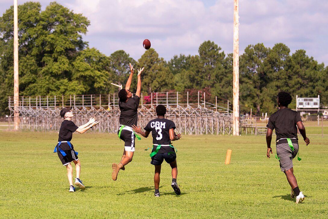 High school students play flag football during summer camp.