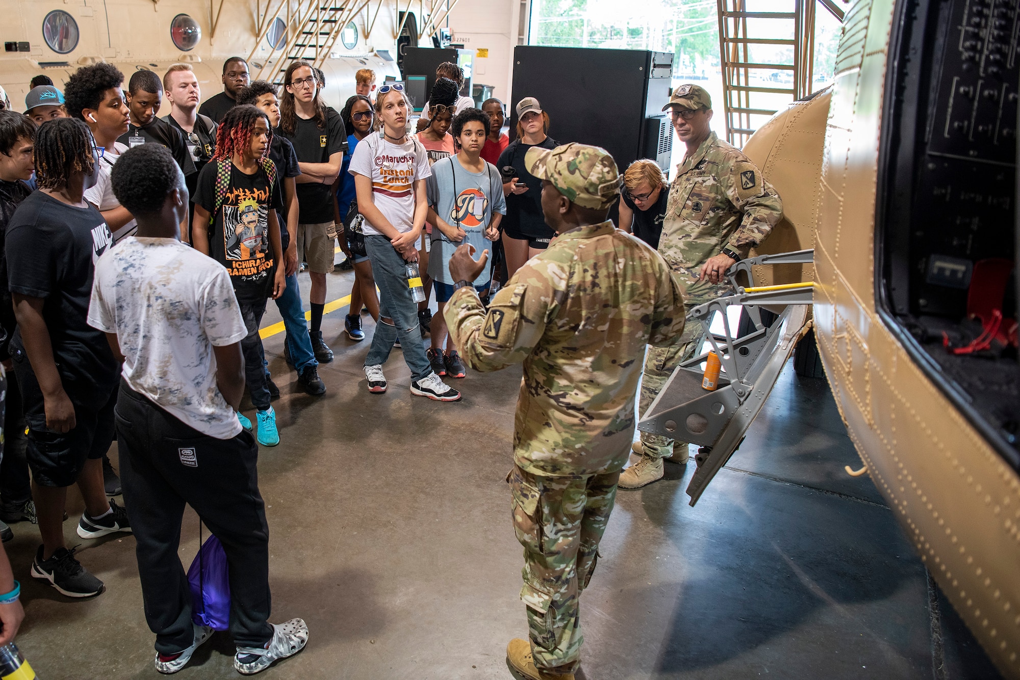 High school students tour a helicopter during summer camp.