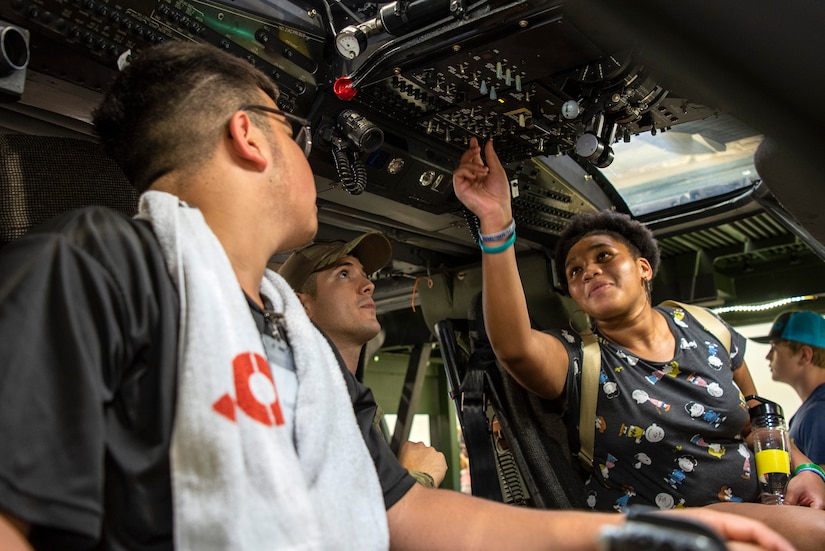 High school students sit in a helicopter simulator during summer camp.