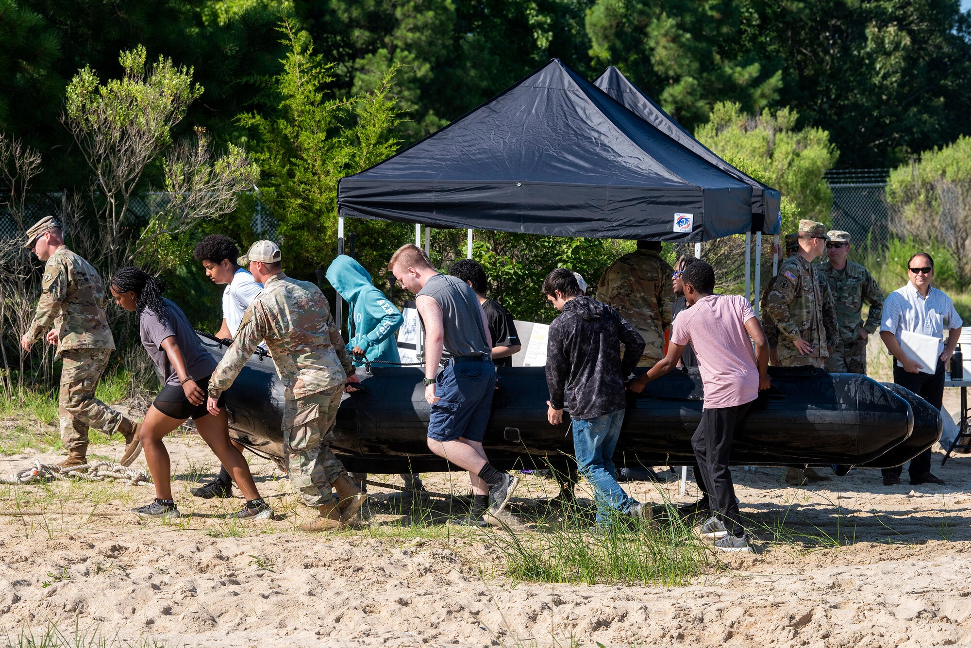 Soldiers and high school students work on a task during summer camp.