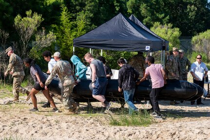 Soldiers and high school students work on a task during summer camp.