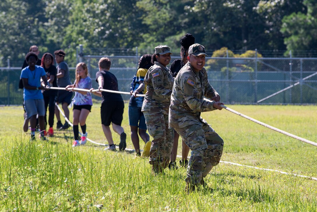 Soldiers and high school students work on a task during summer camp.