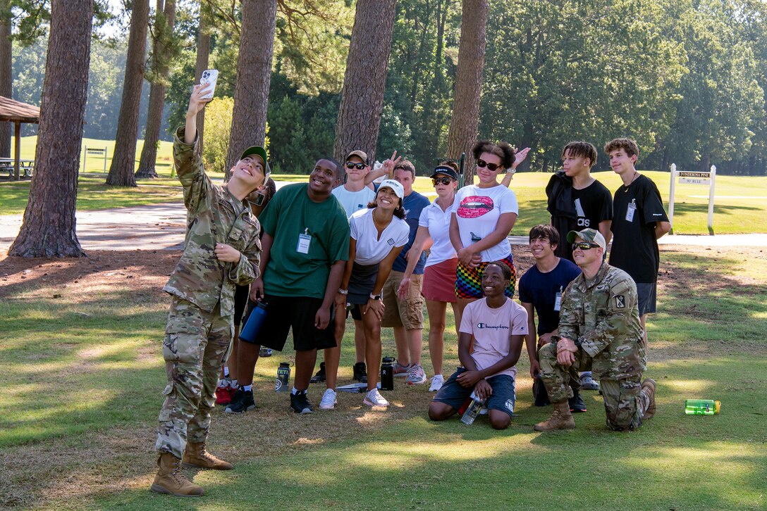 Soldiers and high school students pose for a picture.