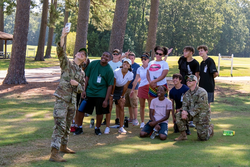 Soldiers and high school students pose for a picture.