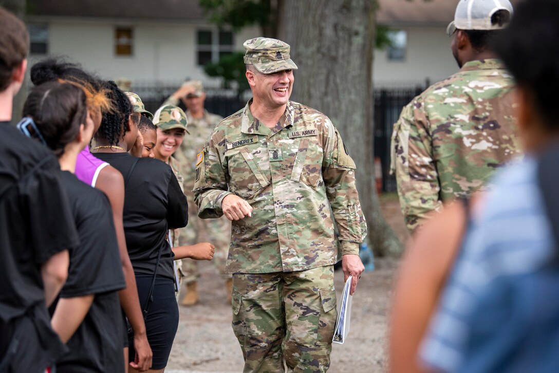 A Solider interacts with high school students.