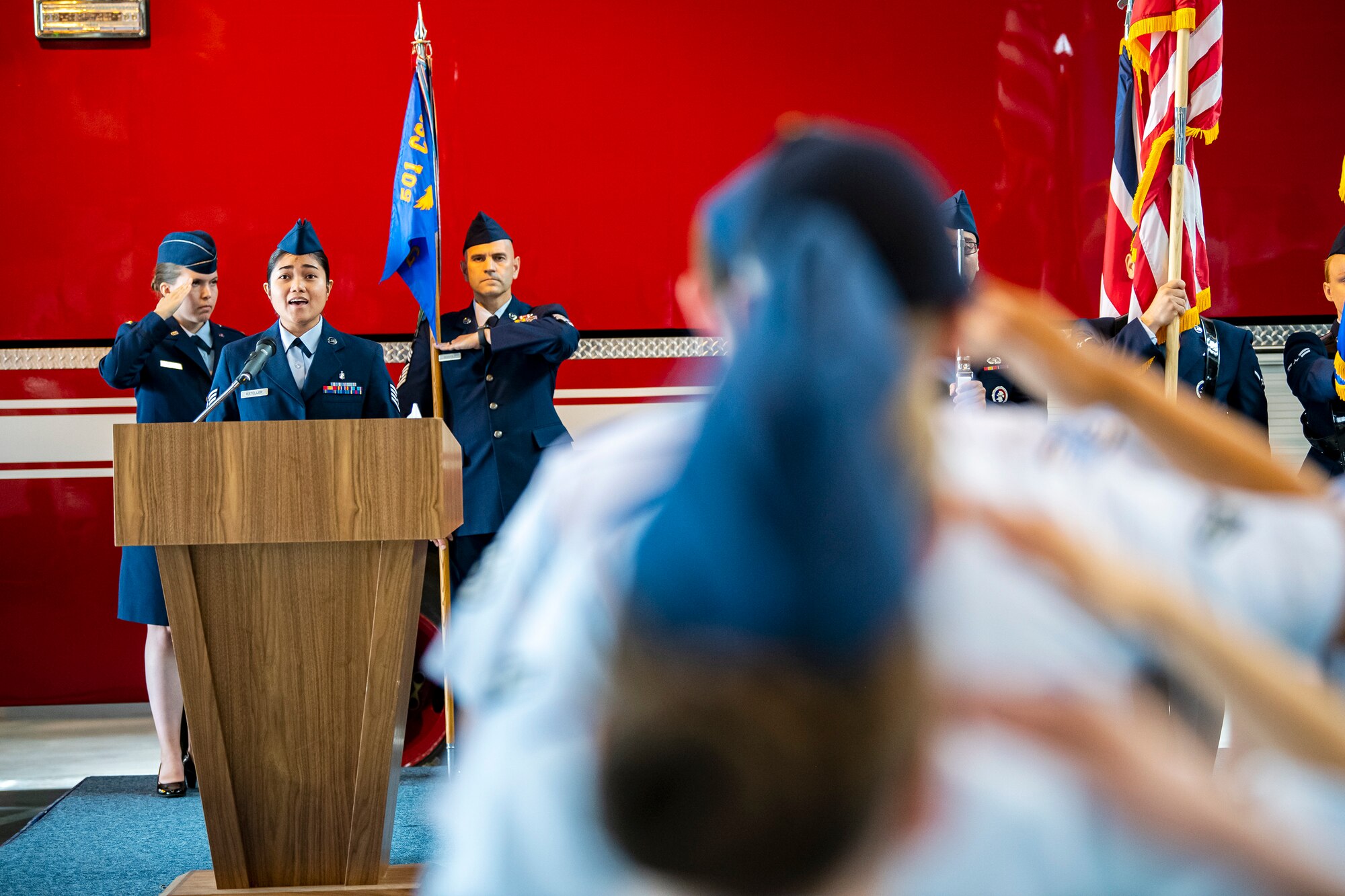U.S. Air Force Staff Sgt. Bloom Esteller, left, 423d Medical Squadron dental assistant, sings the national anthem during a change of command ceremony at RAF Alconbury, England, July 25, 2022. The ceremony is a military tradition that represents a formal transfer of a unit’s authority from one commander to another. (U.S. Air Force photo by Staff Sgt. Eugene Oliver)