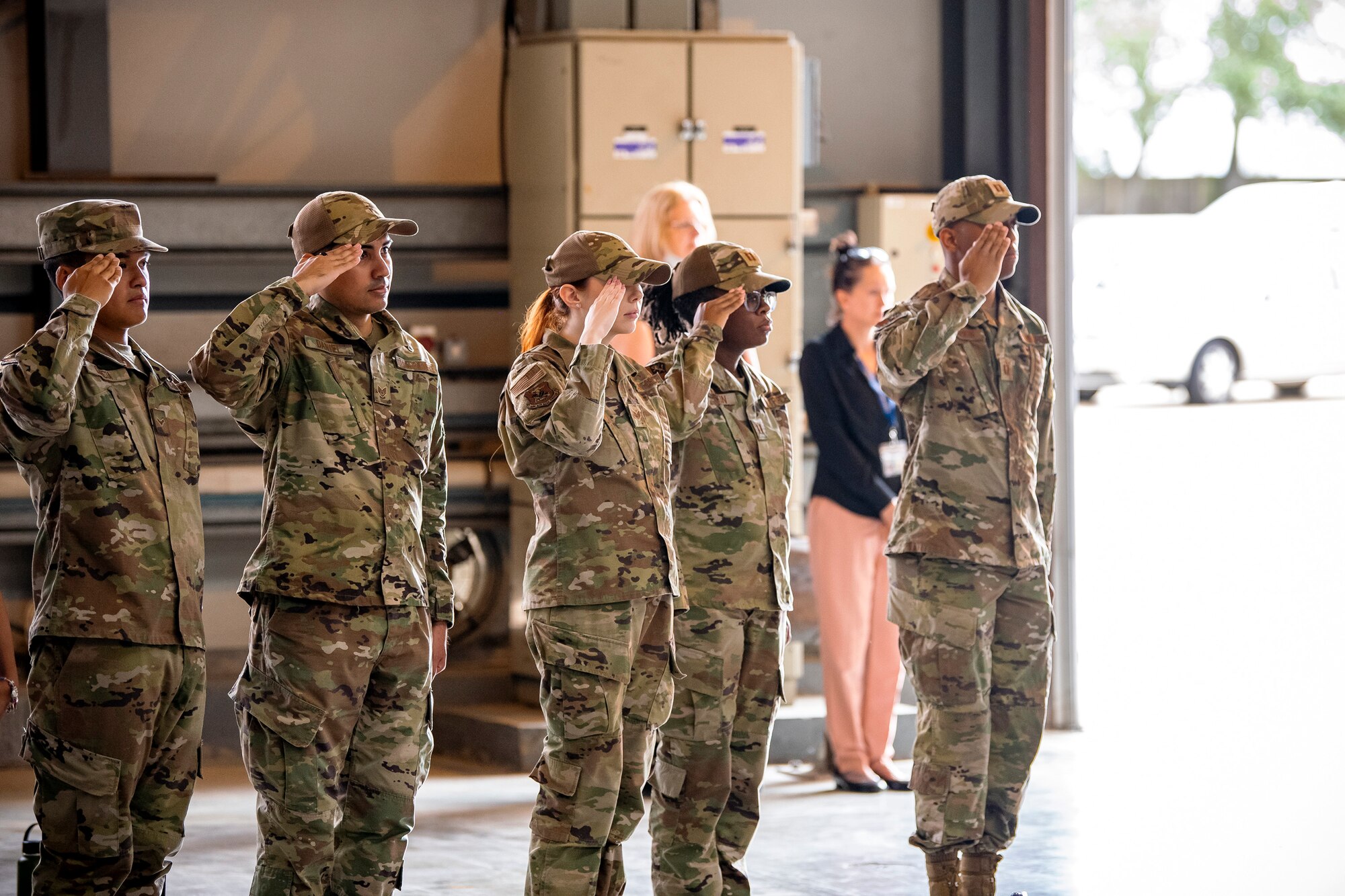 Airmen from the 501st Combat Support Wing salute during a change of command ceremony at RAF Alconbury, England, July 25, 2022. The ceremony is a military tradition that represents a formal transfer of a unit’s authority from one commander to another. (U.S. Air Force photo by Staff Sgt. Eugene Oliver)