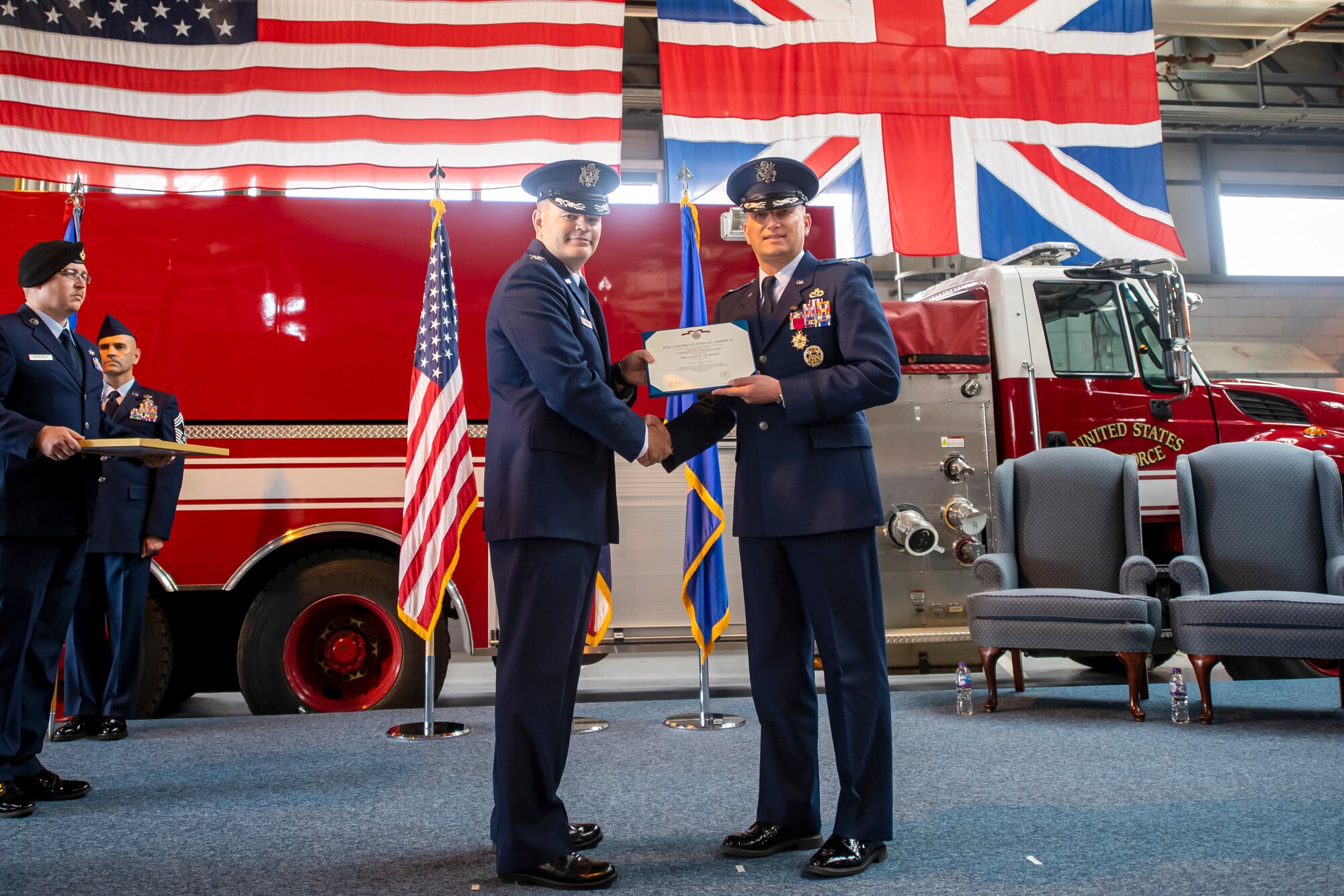 U.S. Air Force Col. Brian Filler, left, 501st Combat Support Wing commander, presents a Legion of Merit citation to Col. Richard Martin, 423d Air Base Group outgoing commander, during a change of command ceremony at RAF Alconbury, England, July 25, 2022. During his command, Martin led a unit that provided a full range of operational, logistical, engineering, medical and communications support and community services to 6,500 military and civilian personnel and families at 4 installations. (U.S. Air Force photo by Staff Sgt. Eugene Oliver)
