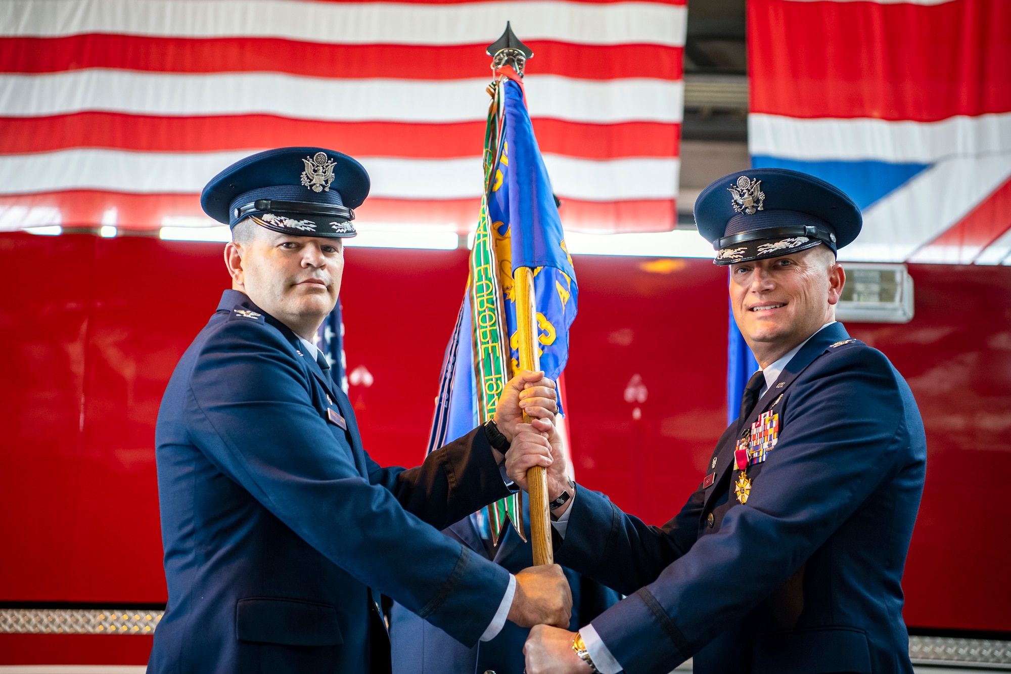 U.S. Air Force Col. Brian Filler, left, 501st Combat Support Wing commander, receives the 423d Air Base Group guidon from Col. Richard Martin, 423d ABG outgoing commander, during a change of command ceremony at RAF Alconbury, England, July 25, 2022. During his command, Martin led a unit that provided a full range of operational, logistical, engineering, medical and communications support and community services to 6,500 military and civilian personnel and families at 4 installations. (U.S. Air Force photo by Staff Sgt. Eugene Oliver)