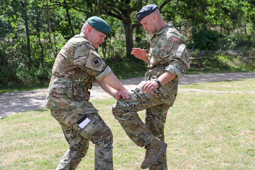 Participants for MREP 2022 work together on team building exercises at Camp Nymindegab July 2, 2022. MREP is a program that houses almost 130 participants from 6 different nations, to increase interoperability, strengthen partnerships, and to enhance professional development between allies.