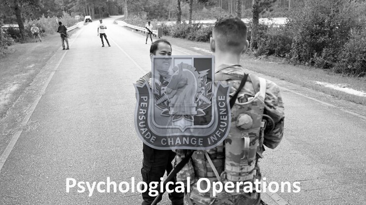 A Soldier assigned to the U.S. Army John F. Kennedy Special Warfare Center and School participating in the Psychological Operations Qualification Course speaks to an indigenous role player during White Knight, the culmination exercise for Psychological Operations students, at Camp Mackall, North Carolina September 20, 2021. The Soldiers underwent various assessments throughout the course consisting of individual physical fitness/confidence events, intelligence/psychological exams/assessments, and individual and team problem-solving (dilema-based) assessments in order to successfully carry out psychological operations and succeed in the special operations community. (U.S. Army photo by K. Kassens)