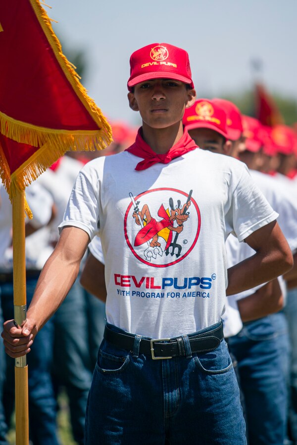 The guide for 4th platoon, stands at parade rest with the platoon guidon during the second increment Devil Pups Youth for America Program graduation at the 11 Area parade deck on Marine Corps Base Camp Pendleton, California, July 23, 2022. The Devil Pups mission is to challenge, educate and help young boys and girls of all backgrounds learn self-reliance and responsibility. The Devil Pups program has been running since 1954. (U.S. Marine Corps photo by Lance Cpl. Straley)