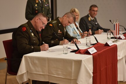 U.S. Army Brig. Gen. Gregory Knight, left, Vermont adjutant general, and U.S. Army Gen. Daniel Hokanson, center left, chief of the National Guard Bureau, sign letters of intent with the Republic of Austria in Vienna, Austria, July 19, 2022, under the State Partnership Program. This is the third state partnership for the Vermont National Guard, which has partnered with North Macedonia since 1993 and Senegal since 2008.