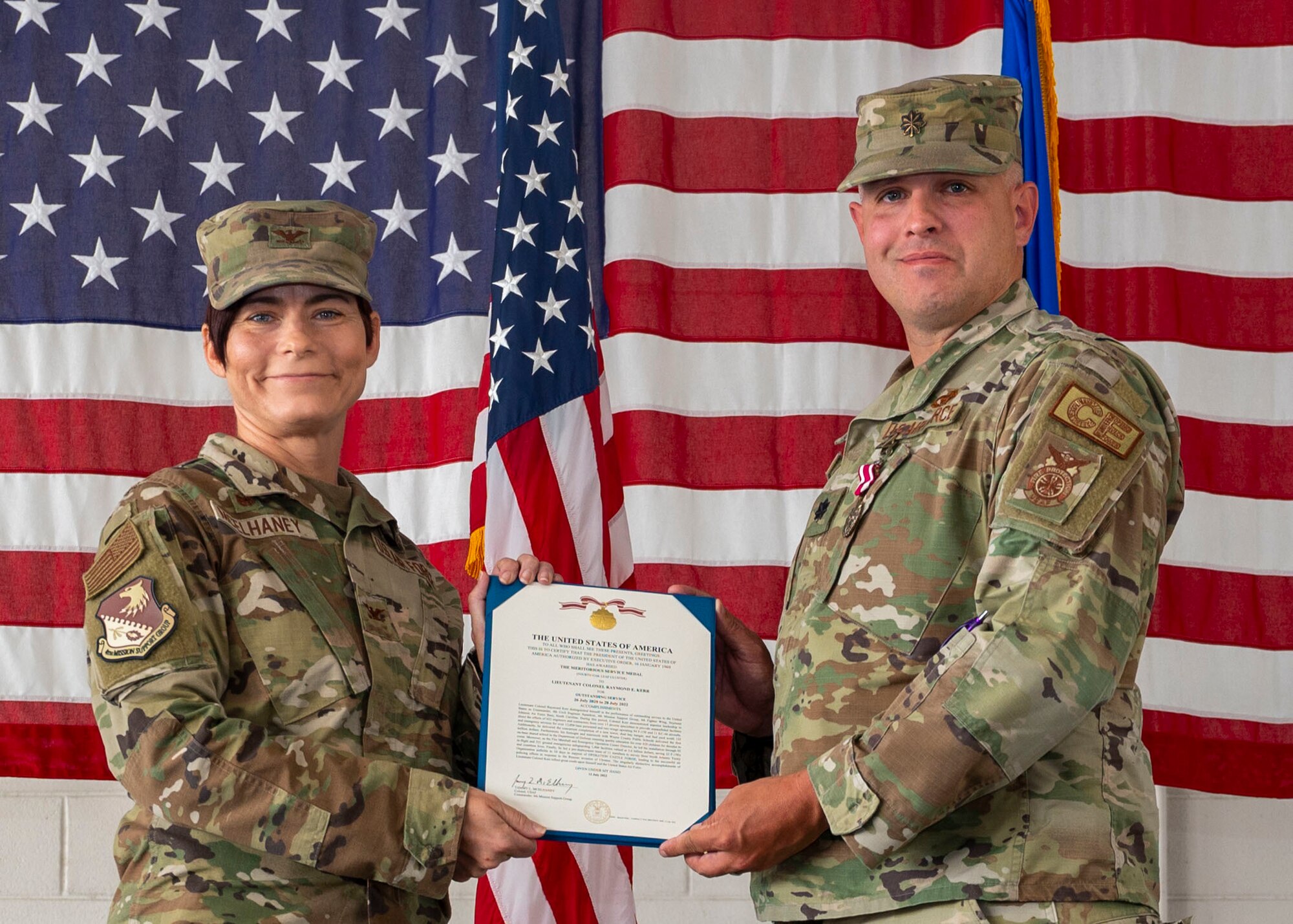 Col. Tammy McElhaney, left, 4th Mission Support Group commander, presents the Meritorious Service Medal to Lt. Col. Raymond Kerr, outgoing 4th Civil Engineer Squadron commander, as he relinquishes command of the 4th CES during a change of command ceremony at Seymour Johnson Air Force Base, North Carolina, July 22, 2022.