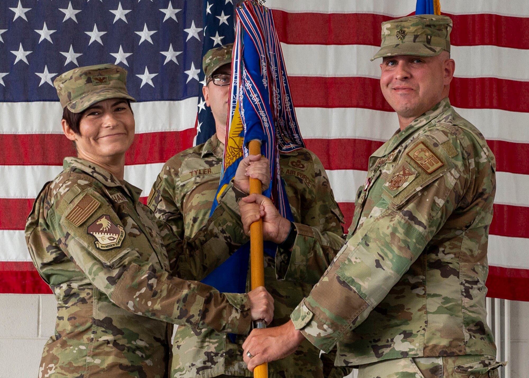 Col. Tammy McElhaney, left, 4th Mission Support Group commander, receives the guidon from Lt. Col. Raymond Kerr, outgoing 4th Civil Engineer Squadron commander, as he relinquishes command of the 4th CES during a change of command ceremony at Seymour Johnson Air Force Base, North Carolina, July 22, 2022.