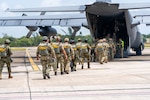 A group of soldiers boards a military aircraft.